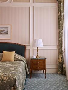 ウィーンにあるGrand Hotel Wienのベッドルーム1室(ベッド1台、ランプ付きテーブル付)