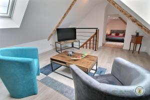 a living room with two chairs and a tv at La forge de la fontaine in Pléhédel