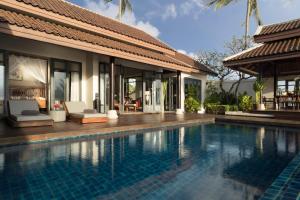 a swimming pool in front of a villa at Anantara Lawana Koh Samui Resort in Chaweng