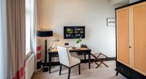 a room with a desk with a chair and a lamp at Astoria Hotel in Lviv +75 photos