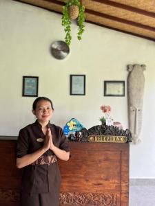 乌鲁瓦图WIRA Homestay & Spa的手站在桌子前的女人 更多37张照片