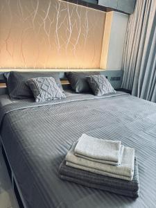 a bed with two towels sitting on top of it at Citygate Kamala Condo Paris in Kamala Beach