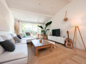 a living room with a couch and a table and a guitar at Maison de la Bonaventure Pérols, piscine et jardin in Pérols