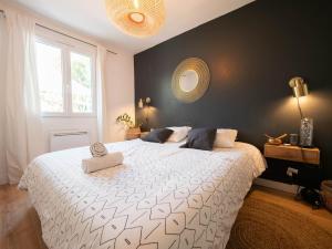 a bedroom with a large white bed with a black wall at Maison de la Bonaventure Pérols, piscine et jardin in Pérols +20 photos
