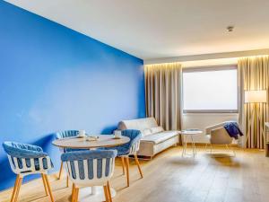 a living room with a couch and a table at Novotel Gdańsk Marina in Gdańsk
