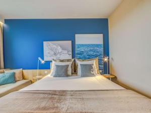 a bedroom with a large bed with a blue wall at Novotel Gdańsk Marina in Gdańsk