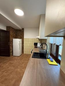 a kitchen with a white refrigerator and a counter top at Domek Bomba Zator Graboszyce in Graboszyce