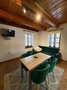 a living room with a wooden table and green chairs at Domek Bomba Zator Graboszyce in Graboszyce