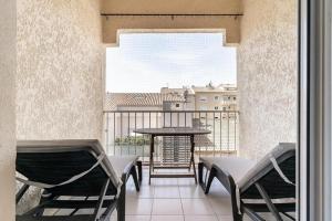 balcón con sillas, mesa y ventana en Duplex Appartement 300m de la mer, en Fréjus