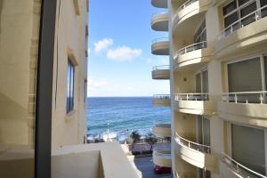 a view of the ocean from the balcony of a building at XL Seafront Home in Sliema in Sliema