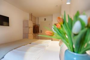 a room with a vase with tulips in it at homie hotel oechsle & brix in Sommerhausen