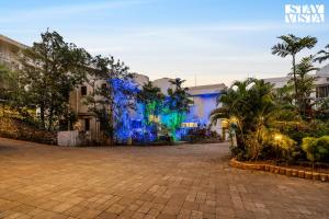 Un edificio con luces azules en el costado. en StayVista at Casa Elyra with Pool, AC, Balcony, en Lonavala