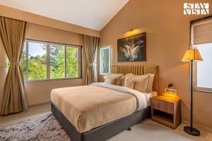 Un dormitorio con una cama grande y una ventana. en StayVista at Casa Elyra with Pool, AC, Balcony, en Lonavala 28 fotos más