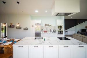a white kitchen with a large marble counter top at Magostales By Silastur in Siero