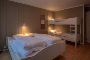 a bedroom with two bunk beds with white sheets at Bakkebyvegen 15A in Trysil