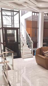 a living room with a staircase and a couch at Rumah 5KT Sby Brt dkt Kidzania in Surabaya