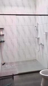 a bathroom with a shower and a toilet at Rumah 5KT Sby Brt dkt Kidzania in Surabaya