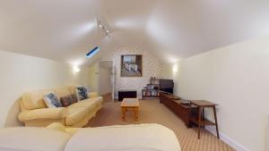 ein Wohnzimmer mit Couch und Kamin in der Unterkunft Hannah Cottage in Adderbury