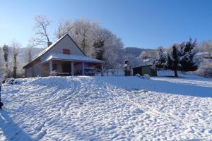 a snow covered driveway with a house in the background at Maison chez alfred in Laborde