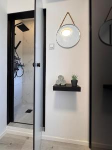 a bathroom with a shower and a light on the door at CityLink Nest Budapest - Free garage, AC & metro access in Budapest +20 photos