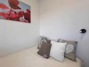 a bed with pillows and a painting on the wall at CityLink Nest Budapest - Free garage, AC & metro access in Budapest +20 photos