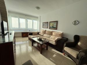 a living room with a couch and a table at Aires de Regla, Apartamentos Living Sur in Chipiona