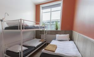 two bunk beds in a room with a window at Hostel Fjordur in Hafnarfjörður