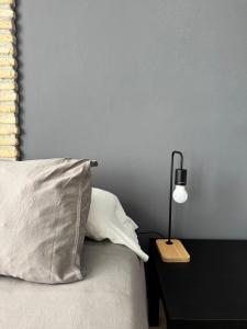 a bed with a pillow and a lamp on a table at Aires de Regla, Apartamentos Living Sur in Chipiona