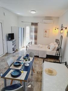 a living room with a dining table and a bedroom at Studio Mimika in Perissa