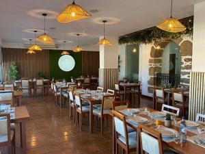 um restaurante com mesas e cadeiras de madeira e luzes em Hotel Eurosol Gouveia em Gouveia