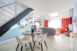a dining room and living room with a table and chairs at Le Duplex - loft - 4 voyageurs in La Riche