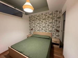 a bedroom with a green bed and a wall at San Matteo Apartments in Loano