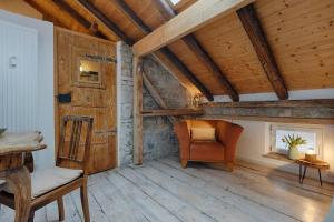 ein Wohnzimmer mit einem Stuhl und Holzdecken in der Unterkunft Weinhotel Oechsle & Brix in Sommerhausen