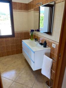 a bathroom with a white sink and a mirror at Bellavista in Castiadas