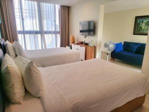 a hotel room with two beds and a blue couch at Beach Oceanami Villa in Long Hai