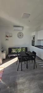 a black table and chairs in a room with a kitchen at Fifty´s House in Ribeira Brava