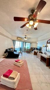 Una sala de estar con una cama y un ventilador de techo. en 20FL Beach Front Huge 1-Bed Condo Next to 5-Star Hotels, en Pattaya central