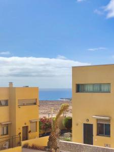 a yellow building with the ocean in the background at Aire de Oceano in Costa de Antigua