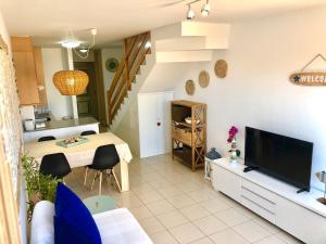 a living room with a television and a table with chairs at Aire de Oceano in Costa de Antigua