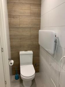 a bathroom with a white toilet and a wooden wall at Lotus Shack - charming and private in Russell Island +28 photos