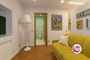 a living room with a yellow couch and a television at C M Barberini Vacation in Rome