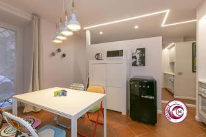 a kitchen with a table and a white refrigerator at C M Barberini Vacation in Rome