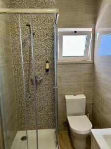 a bathroom with a shower and a toilet and a window at Gomes Equestre in Golegã +10 photos