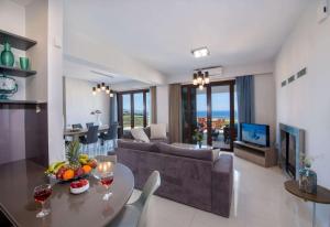 a living room with a couch and a table at Marilia by Vintage Travel in Maleme