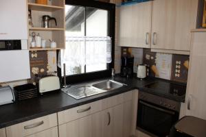 une cuisine avec un évier et une fenêtre dans l'établissement Ferienhaus Nr 29, Kategorie Königscard, Feriendorf Hochbergle, Allgäu, à Bichel