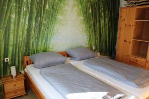 - une chambre avec un lit et un mur vert en bambou dans l'établissement Ferienhaus Nr 29, Kategorie Königscard, Feriendorf Hochbergle, Allgäu, à Bichel