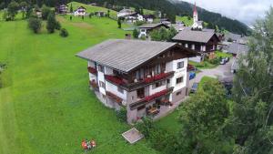 ein großes Haus auf einem Hügel mit grünem Feld in der Unterkunft Haus Blatthofer in Sankt Lorenzen im Lesachtal