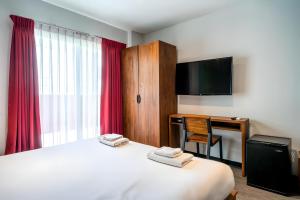 a hotel room with a bed and a desk and a television at X GO INN Sukhumvit Soi 20 BTS Asok in Bangkok +30 photos