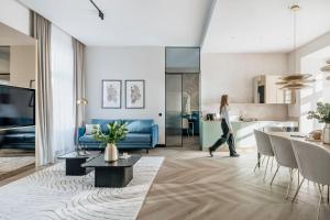 克拉科夫Millou - LoftAffair Collection的女人穿过客厅和厨房