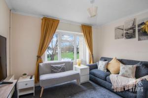 a living room with a blue couch and a chair at Contractors 4 Bed with Parking in Hatfield